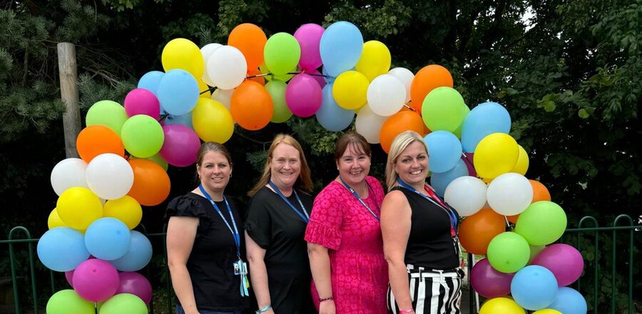 Friends of Sandown members, surrounded by colourful balloons.