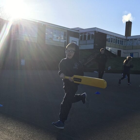 Boy in the playground running with cricket bat