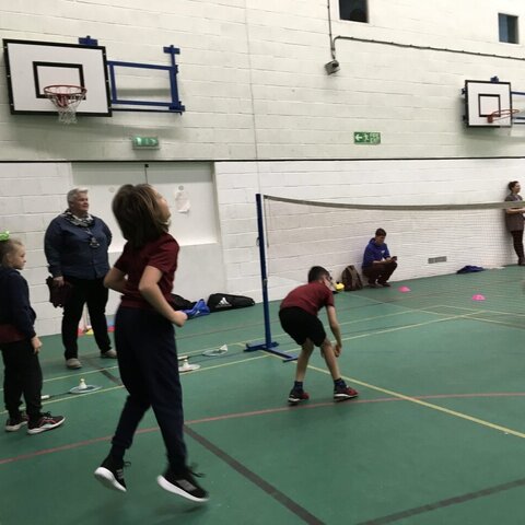 Pupils getting ready to return the shuttle cock in a game of badminton