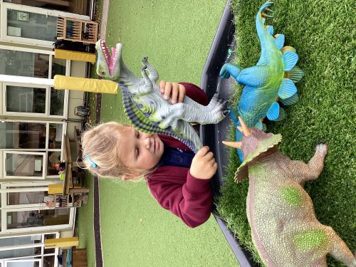 Child playing with toys outside a classroom